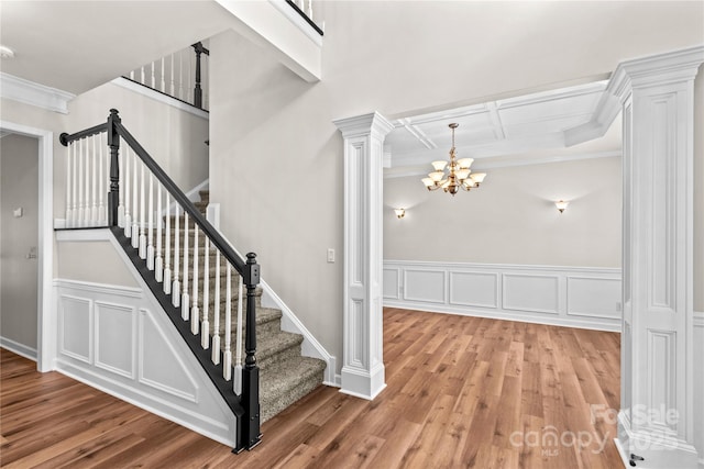 1011 Wadsworth Ln, Indian Trail, NC 28079 - stairway featuring decorative columns, ornamental molding, wood finished floors, a chandelier, and coffered ceiling