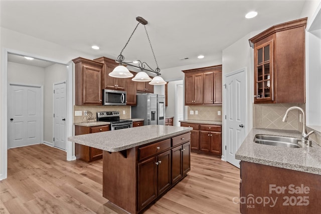 1011 Wadsworth Ln, Indian Trail, NC 28079 - kitchen featuring stainless steel appliances, a kitchen island, light wood finished floors, recessed lighting, and glass insert cabinets