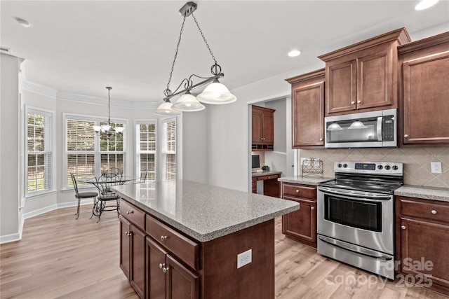 1011 Wadsworth Ln, Indian Trail, NC 28079 - kitchen featuring stainless steel appliances, light wood-style flooring, tasteful backsplash, a center island, and ornamental molding