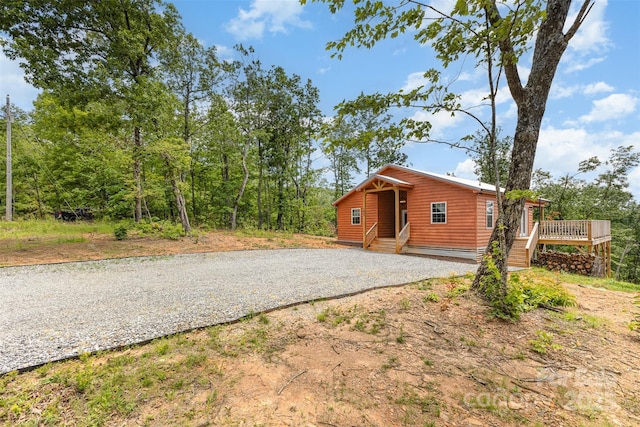 7025 Martin Ln, Morganton, NC 28655 - view of front facade featuring log veneer siding, a deck, and gravel driveway