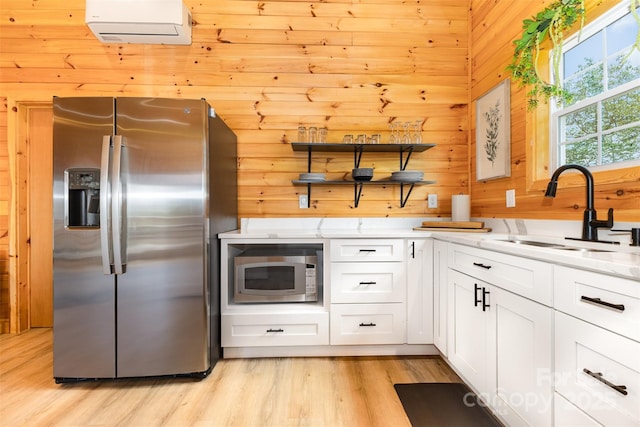 7025 Martin Ln, Morganton, NC 28655 - kitchen featuring stainless steel appliances, light stone counters, white cabinets, a wall unit AC, and wooden walls
