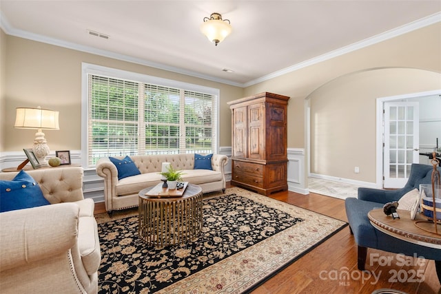 1805 Trading Path Ln, Waxhaw, NC 28173 - living room featuring arched walkways, ornamental molding, wood finished floors, and wainscoting