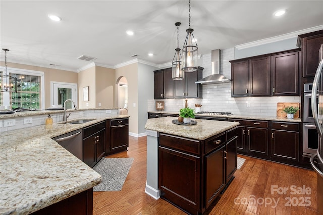 1805 Trading Path Ln, Waxhaw, NC 28173 - kitchen featuring wall chimney exhaust hood, a center island, stainless steel appliances, arched walkways, and tasteful backsplash
