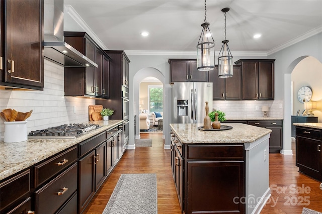1805 Trading Path Ln, Waxhaw, NC 28173 - kitchen with arched walkways, wall chimney exhaust hood, stainless steel appliances, a kitchen island, and dark brown cabinets