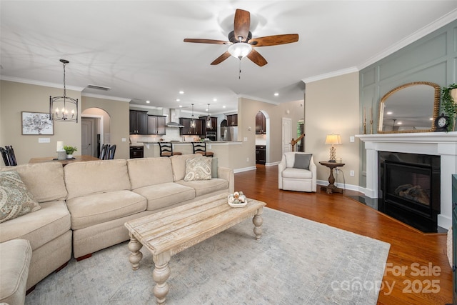 1805 Trading Path Ln, Waxhaw, NC 28173 - living room with arched walkways, ceiling fan, a glass covered fireplace, recessed lighting, and crown molding