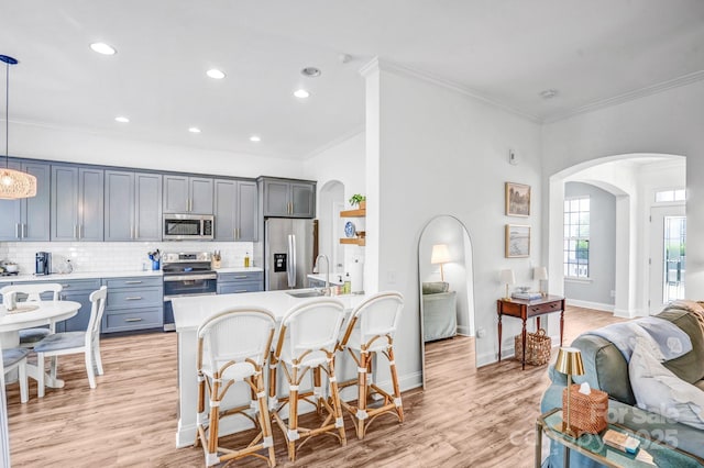 10509 Serape Rd, Charlotte, NC 28277 - kitchen with stainless steel appliances, arched walkways, decorative backsplash, a breakfast bar area, and crown molding