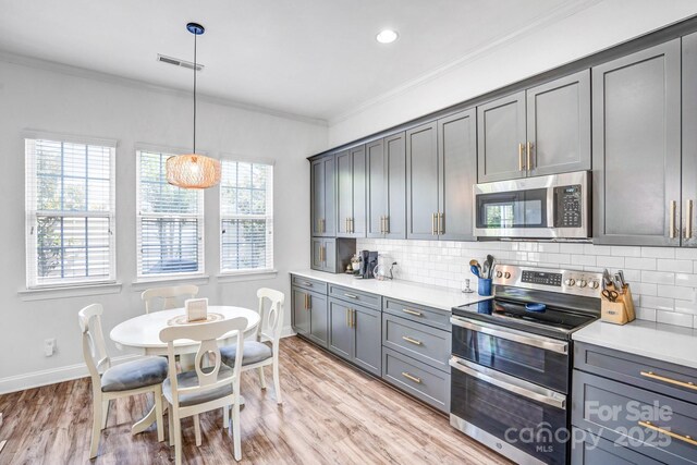 10509 Serape Rd, Charlotte, NC 28277 - kitchen with stainless steel appliances, crown molding, gray cabinets, tasteful backsplash, and light countertops