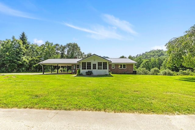 100 Nimitz Dr, Brevard, NC 28712 - ranch-style house with a front yard, an attached carport, a metal roof, and brick siding
