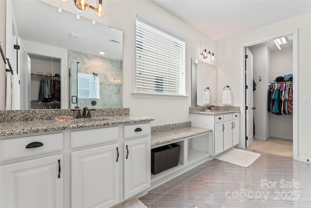 9547 Horsebit Ln, Concord, NC 28027 - bathroom with vanity, a shower stall, a walk in closet, and healthy amount of natural light