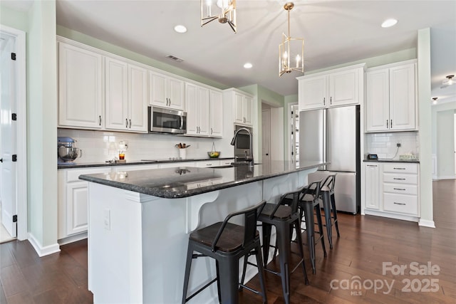 9547 Horsebit Ln, Concord, NC 28027 - kitchen with stainless steel appliances, a chandelier, dark wood-type flooring, decorative backsplash, and recessed lighting