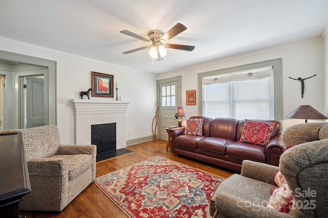 576 Washington Ave NW, Valdese, NC 28690 - living room with ceiling fan, a brick fireplace, ornamental molding, and wood finished floors