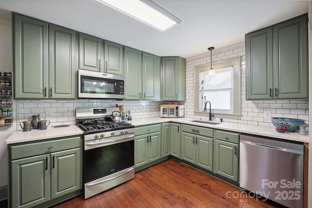 576 Washington Ave NW, Valdese, NC 28690 - kitchen featuring appliances with stainless steel finishes, green cabinets, and decorative backsplash