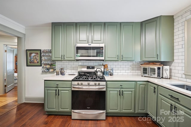 576 Washington Ave NW, Valdese, NC 28690 - kitchen with green cabinets, stainless steel appliances, light countertops, and tasteful backsplash