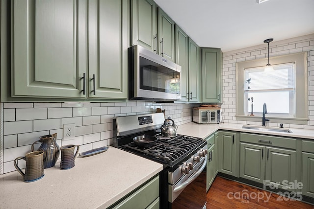 576 Washington Ave NW, Valdese, NC 28690 - kitchen with green cabinetry, appliances with stainless steel finishes, tasteful backsplash, light countertops, and dark wood-style flooring