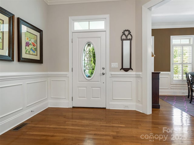 8918 Cotton Press Rd, Charlotte, NC 28277 - foyer featuring dark wood finished floors, a decorative wall, ornamental molding, and wainscoting