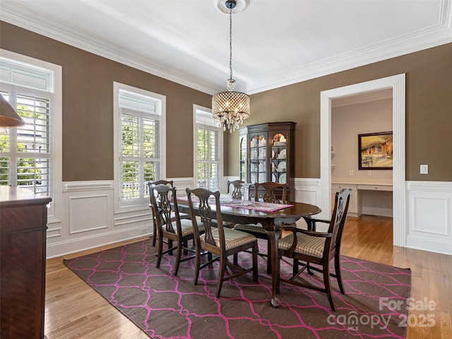 8918 Cotton Press Rd, Charlotte, NC 28277 - dining space with a chandelier, healthy amount of natural light, wood finished floors, wainscoting, and ornamental molding