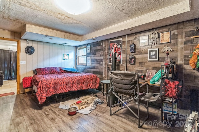 1713 Poe Cir, Hickory, NC 28601 - bedroom with wooden walls, wood finished floors, and a textured ceiling