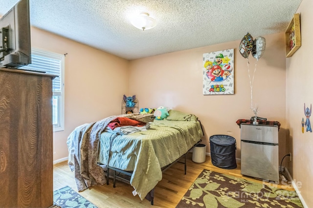 1713 Poe Cir, Hickory, NC 28601 - bedroom featuring freestanding refrigerator, wood finished floors, and a textured ceiling