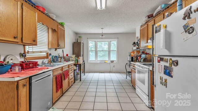 1713 Poe Cir, Hickory, NC 28601 - kitchen featuring white appliances, light countertops, a textured ceiling, brown cabinets, and light tile patterned floors