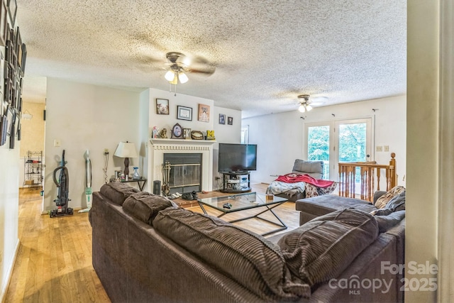 1713 Poe Cir, Hickory, NC 28601 - living area featuring ceiling fan, light wood-type flooring, a glass covered fireplace, and a textured ceiling