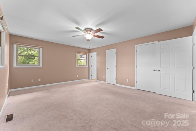 435 Pauline Ave, Franklin, NC 28734 - unfurnished bedroom featuring multiple closets, light carpet, and multiple windows