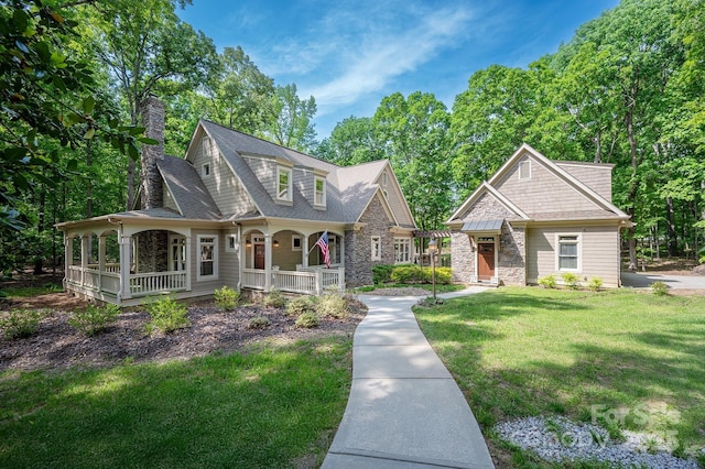 3408 Sandalwood Ln, Waxhaw, NC 28173 - view of front of home featuring covered porch, a front lawn, a chimney, and stone siding
