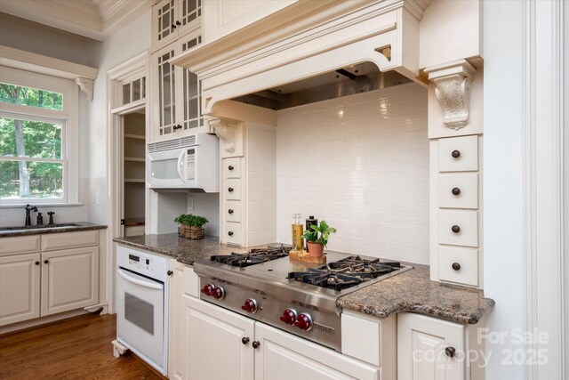 3408 Sandalwood Ln, Waxhaw, NC 28173 - kitchen featuring white appliances, backsplash, custom range hood, glass insert cabinets, and ornamental molding