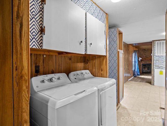 70 John Delk Rd, Hendersonville, NC 28792 - laundry area featuring washing machine and clothes dryer, cabinet space, wood walls, and a fireplace