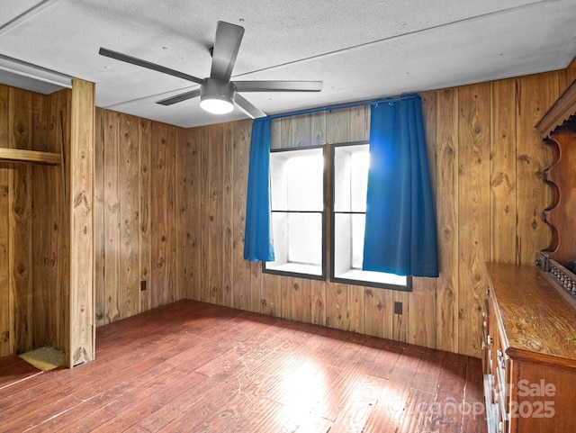 70 John Delk Rd, Hendersonville, NC 28792 - spare room with hardwood / wood-style flooring, wooden walls, ceiling fan, and a textured ceiling