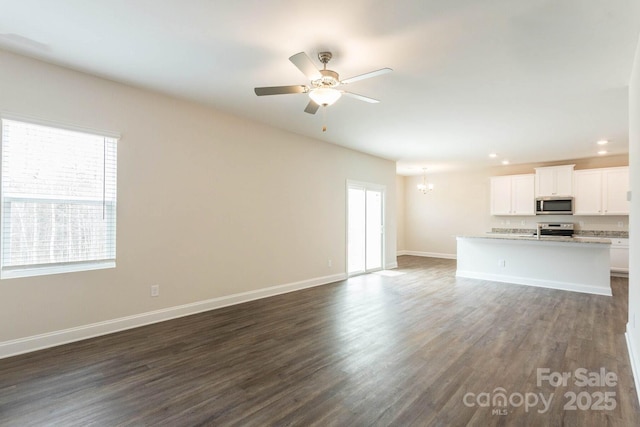 116 Kennford Trl, Troutman, NC 28166 - unfurnished living room featuring ceiling fan, dark wood-style flooring, recessed lighting, and a chandelier
