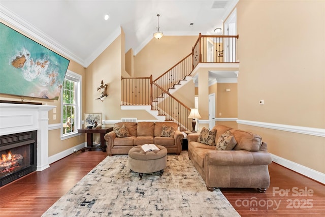 2074 Brandt Rd, York, SC 29745 - living room featuring dark wood-type flooring, ornamental molding, high vaulted ceiling, stairway, and a glass covered fireplace