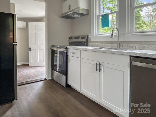 33 Graybark Ct, Waynesville, NC 28786 - kitchen with appliances with stainless steel finishes, dark wood finished floors, white cabinetry, and a wall unit AC