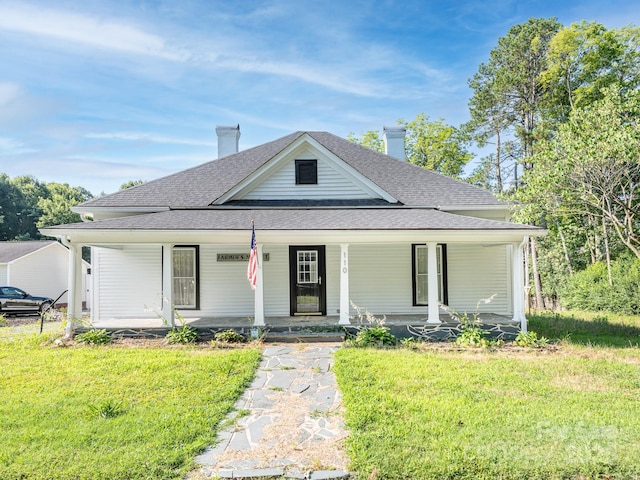 110 College St, Marshville, NC 28103 - farmhouse inspired home featuring a shingled roof, a front yard, a chimney, and covered porch