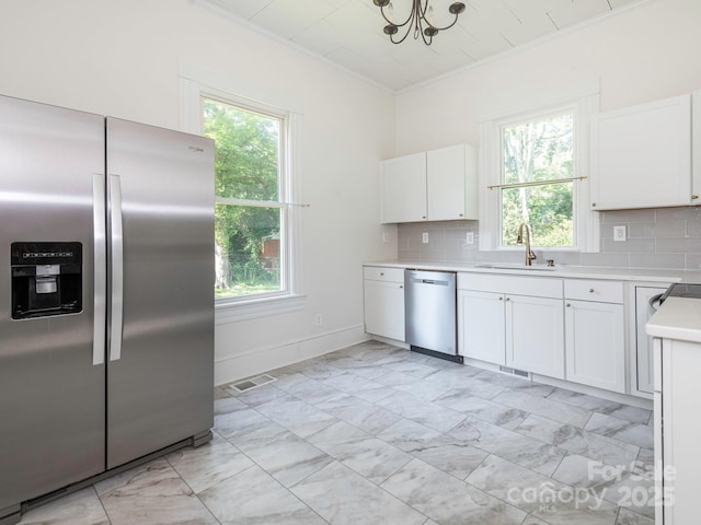 110 College St, Marshville, NC 28103 - kitchen with stainless steel appliances, crown molding, light countertops, light marble finish floors, and backsplash