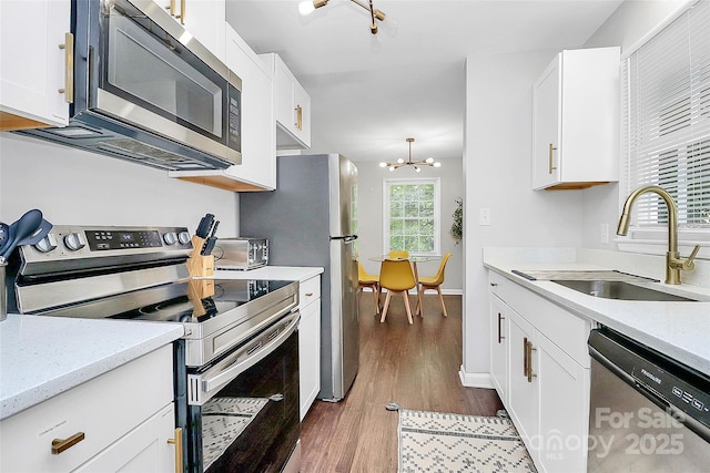 3909 Woodbriar Trl, Charlotte, NC 28205 - kitchen featuring stainless steel appliances, dark wood-style flooring, white cabinets, and a chandelier