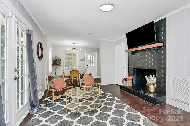 3909 Woodbriar Trl, Charlotte, NC 28205 - living area featuring wood finished floors, a fireplace, a chandelier, and ornamental molding