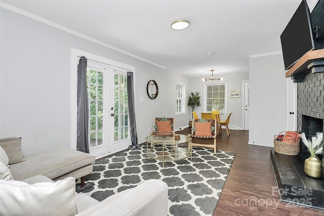 3909 Woodbriar Trl, Charlotte, NC 28205 - living area featuring dark wood-style flooring, crown molding, a chandelier, and a brick fireplace