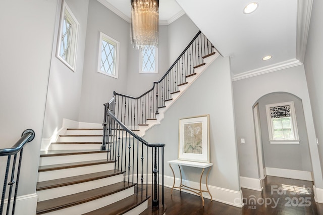15603 June Washam Rd, Davidson, NC 28036 - staircase featuring healthy amount of natural light, arched walkways, a chandelier, wood finished floors, and crown molding