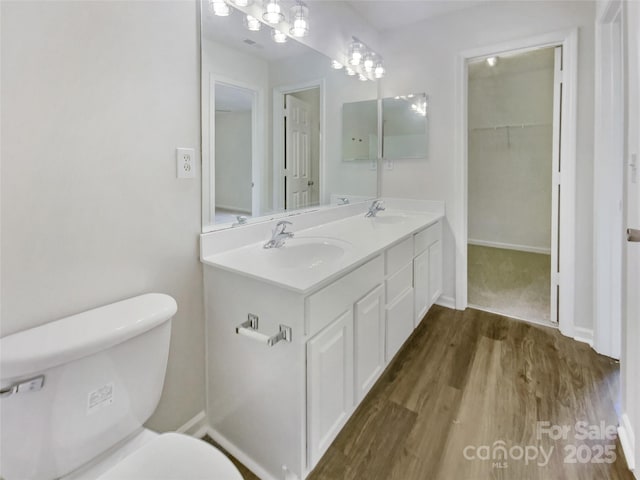 5163 Ficus Tree Ln, Charlotte, NC 28215 - bathroom with wood finished floors, double vanity, and a walk in closet