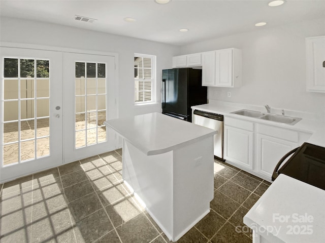 5163 Ficus Tree Ln, Charlotte, NC 28215 - kitchen featuring stainless steel dishwasher, freestanding refrigerator, french doors, white cabinets, and light countertops