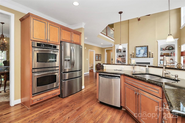 13824 Glen Abbey Dr, Charlotte, NC 28278 - kitchen with appliances with stainless steel finishes, brown cabinetry, ornamental molding, light wood-type flooring, and hanging light fixtures