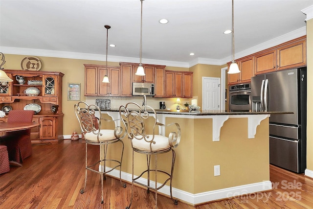 13824 Glen Abbey Dr, Charlotte, NC 28278 - kitchen with appliances with stainless steel finishes, a kitchen breakfast bar, brown cabinetry, decorative light fixtures, and crown molding