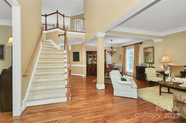 13824 Glen Abbey Dr, Charlotte, NC 28278 - living room with wood finished floors, a chandelier, stairs, and crown molding