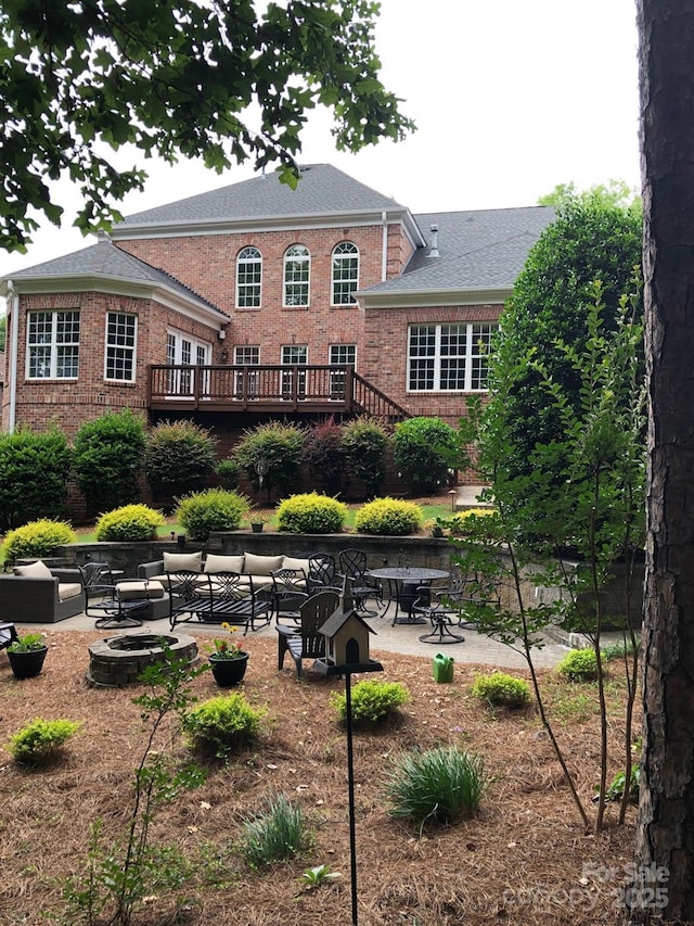 13824 Glen Abbey Dr, Charlotte, NC 28278 - back of property with brick siding, an outdoor fire pit, a patio, and a shingled roof