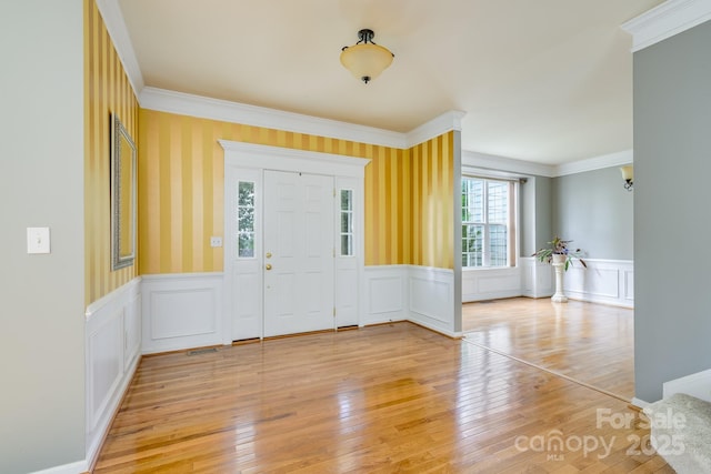 7737 Pleasant Valley Dr, Harrisburg, NC 28075 - foyer entrance featuring ornamental molding, a wainscoted wall, light wood-style floors, and a decorative wall