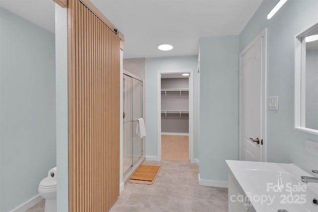 2926 Royal Fern Ln, Charlotte, NC 28215 - bathroom featuring a shower stall, tile patterned floors, vanity, a walk in closet, and recessed lighting