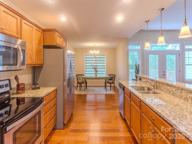 29 Kaylor Dr, Arden, NC 28704 - kitchen with stainless steel appliances, a chandelier, light wood-style flooring, brown cabinets, and plenty of natural light
