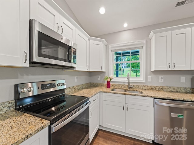 101 Meadowbrook Dr, Franklin, NC 28734 - kitchen with stainless steel appliances, white cabinets, dark wood-type flooring, light stone counters, and vaulted ceiling