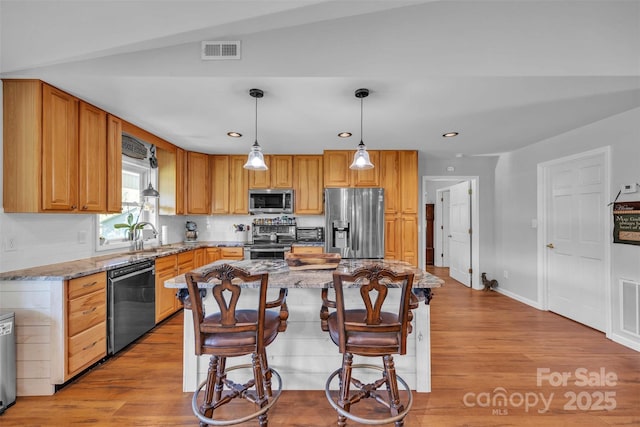 5158 Jenkins Rd, Morganton, NC 28655 - kitchen with appliances with stainless steel finishes, light wood-type flooring, light stone countertops, a kitchen bar, and recessed lighting