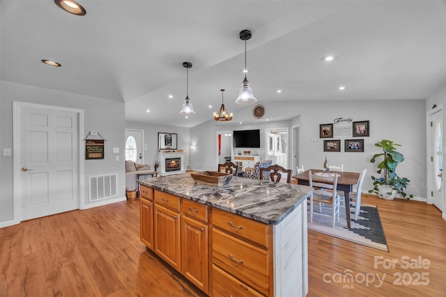 5158 Jenkins Rd, Morganton, NC 28655 - kitchen featuring lofted ceiling, open floor plan, a kitchen island, light wood-style floors, and dark stone countertops